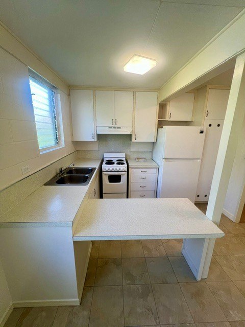 A kitchen with white cabinets and a white table.